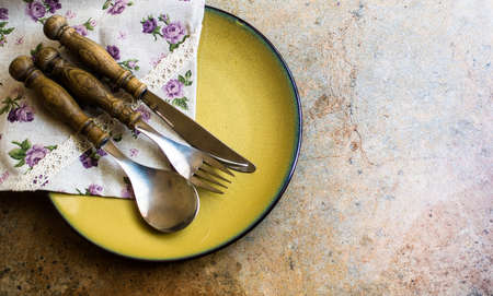 Rustic table setting with vintage silverware and plates on stone tableの写真素材