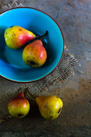 ripe pear with red side on rustic stone tableの写真素材
