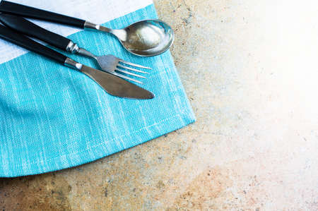Rustic table setting with vintage silverware and plates on stone tableの写真素材