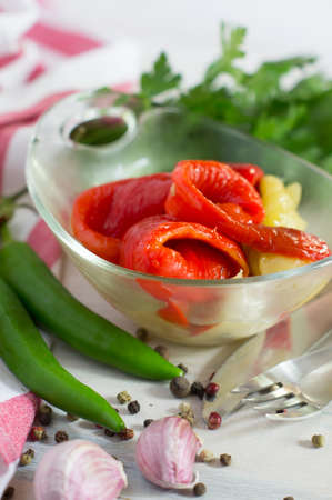Chili peppers in marinade on the plate with spices and parsley on rustic backgroundの写真素材