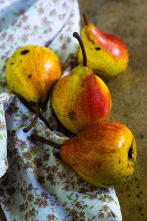 ripe pear with red side on rustic stone table