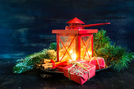 Christmas time red latern  with candle light and giftsの写真素材