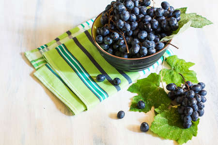 Fresh organic autumnal fruits and rustic plates on old wooden tableの写真素材