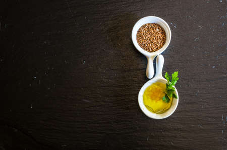 Flax seeds and oil with parsley oon blackboard
