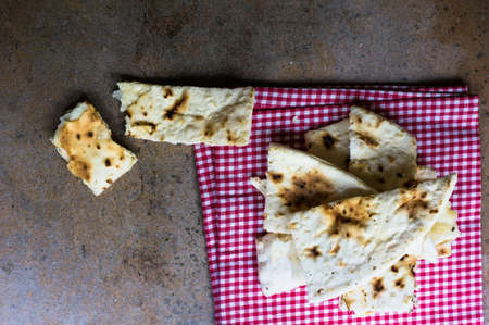 Italian focaccia bread with rosemary and garlic on rustic tableの写真素材
