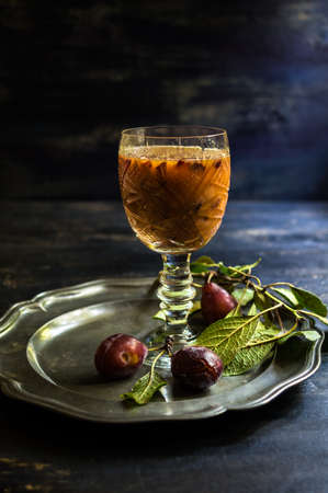 Glass of plum's smoothie and fresh organic plums on rustic tableの写真素材