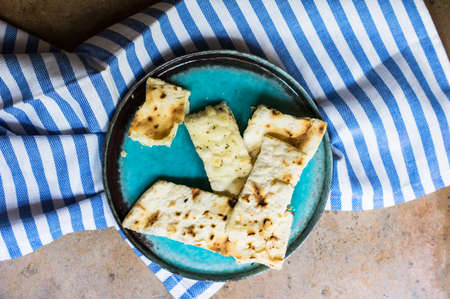 Italian focaccia bread with rosemary and garlic on rustic table