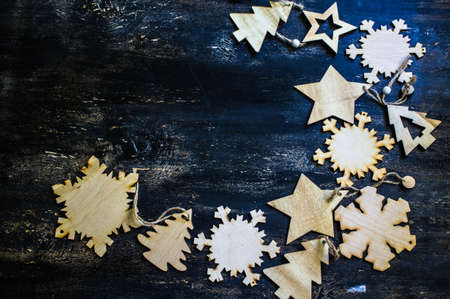 Christmas wooden snowflakes on dark rustic wooden background with copy spaseの写真素材