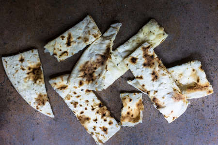Italian focaccia bread with rosemary and garlic on rustic tableの写真素材