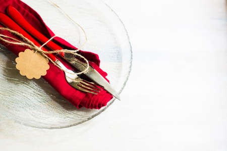 Christmas table setting with bright napkin and vintage silverware on rustic wooden tableの写真素材