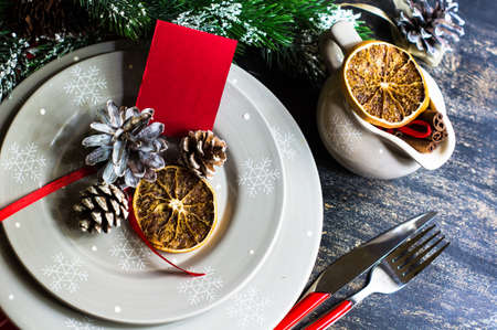 Christmas table setting with bright napkin, spices, decorations and vintage silverware on rustic...
