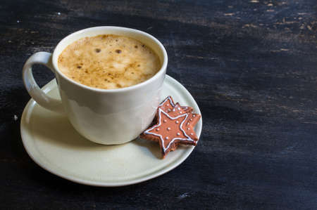 Cup of cappuccino with cinnamon spice and Christmas decoration on dark rustic backgroundの写真素材