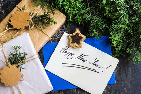 Gift boxes and cards for Christmas celebration with festive decorations on rustic wooden backgroubd...