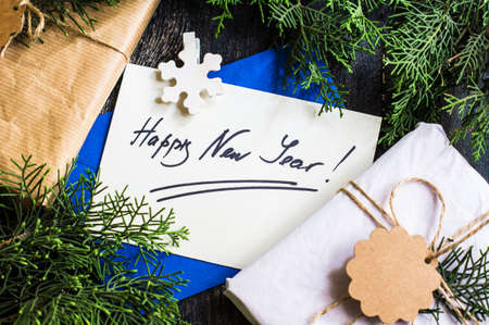 Gift boxes and cards for Christmas celebration with festive decorations on rustic wooden backgroubd with copyspaceの写真素材