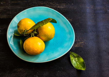 Fresh organic tangerine fruits on rustic wooden table and copyspaceの写真素材