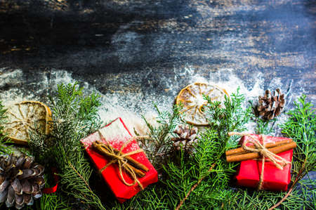 Christmas frame with spices, gift boxes, oranges, pine tree and cone for Christmas with copyspace