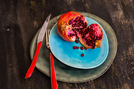 Ripe organic pomegranate fruit on rustic wooden table with copyspaceの写真素材