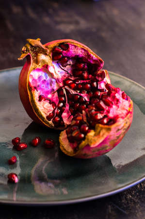 Ripe organic pomegranate fruit on rustic wooden table with copyspaceの写真素材