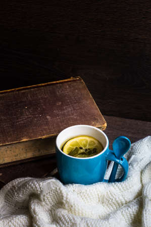 Spiced tea with lemon with knitted scarf on wooden tableの写真素材