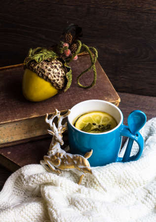 Spiced tea with lemon with knitted scarf on wooden tableの写真素材