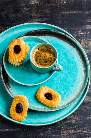 Cup of coffee and blueberry cookies on ceramic platesの写真素材