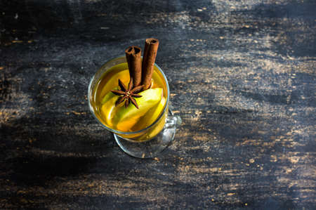 Apple cider with cinnamon sticks and fresh organic apples on dark wooden backgroundの写真素材