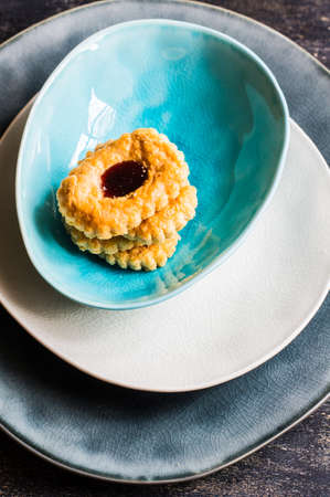 Tasty blueberry cookies on ceramic plates on dark wooden tableの写真素材