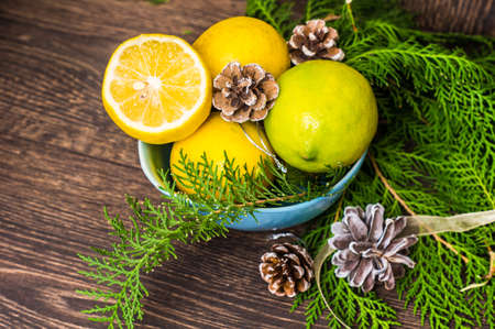 Fresh organic lemons and Chritmas tree decorations on dark wooden tableの写真素材