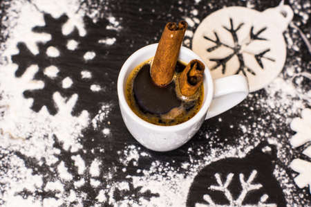 Cup of coffee with christmas decorations on dark wooden table with copyspace
