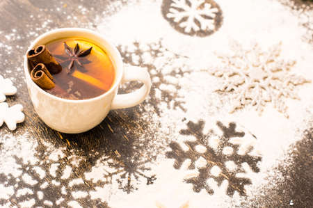 Cup of Tea with a Lemon and Cinnamon on Christmas background with snow in rustic style with copyspaceの写真素材