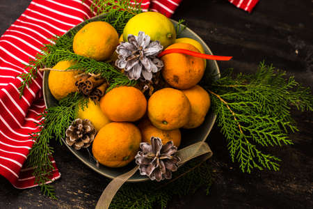 Fresh organic tangerines on dark wooden table