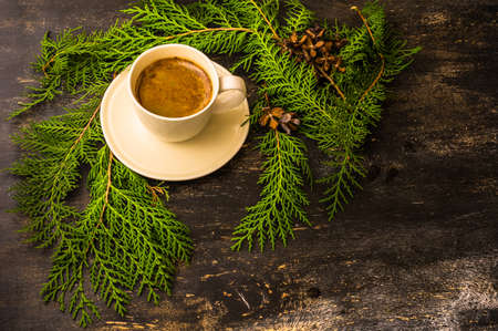 Cup of coffee with christmas decorations on dark wooden table with copyspaceの写真素材