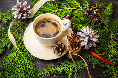 Cup of coffee with christmas decorations on dark wooden table with copyspaceの写真素材