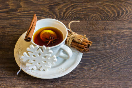 Mulled tea with spices and festive Christmas decorations on dark wooden background with copyspaceの写真素材