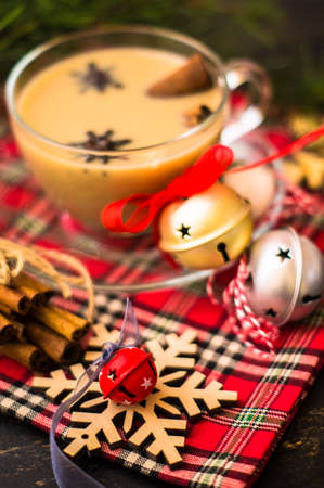 Cup of coffee with milk and spices on decorated for Christmas dark background