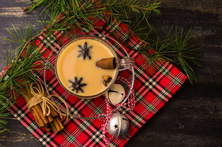 Cup of coffee with milk and spices on decorated for Christmas dark backgroundの写真素材