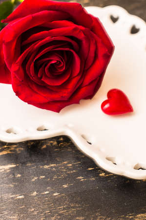 Festive table seting with red rose and heart on dark rustic table with copyspaceの写真素材