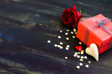 Present for St. Valentines Day  with red ribbon on rustic wooden background with copyspace