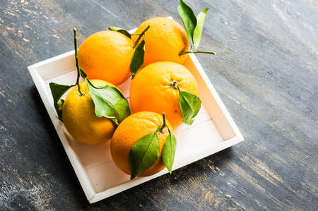Ripe organic oranges on dark rustic wooden tableの写真素材