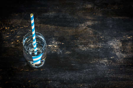 Glass of cold water on rustic dark wooden table with copyspaceの写真素材