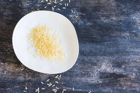 Porcelain plate and rice on dark wooden table with copyspaceの写真素材