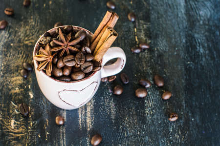 Vintage coffee mug with raw coffee beans on dark rustic wooden backgroundの写真素材