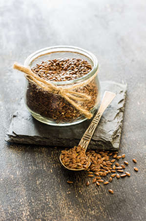 Organic food concept with flax seeds on dark wooden backgroundの写真素材