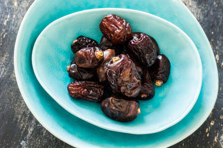 Raw Organic Medjool Dates Ready to Eat on dar wooden tableの写真素材