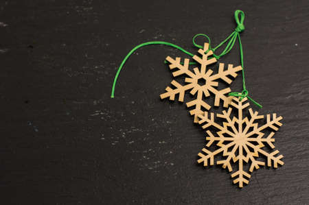 Wooden snow flakes with green ribbon on blackboardの写真素材