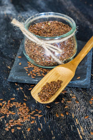 Organic food concept with flax seeds on dark wooden backgroundの写真素材