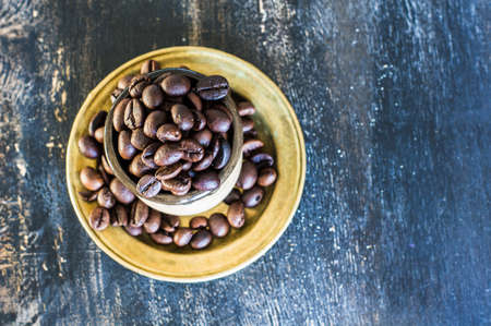 Vintage coffee mug with raw coffee beans on dark rustic wooden backgroundの写真素材