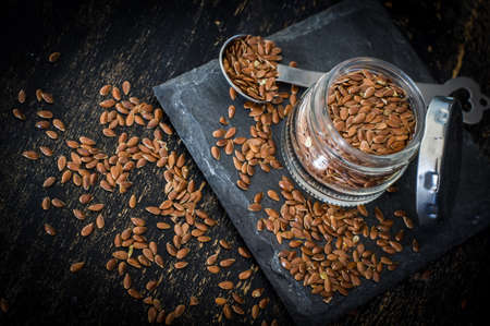 Organic food concept with flax seeds on dark wooden background
