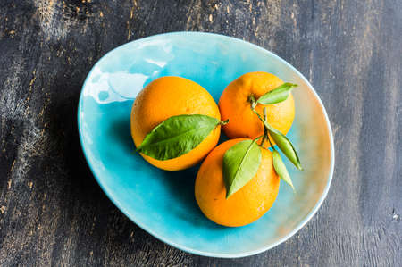 Ripe organic oranges on dark rustic wooden tableの写真素材