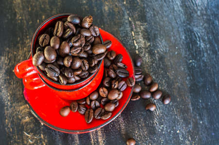 Vintage coffee mug with raw coffee beans on dark rustic wooden backgroundの写真素材